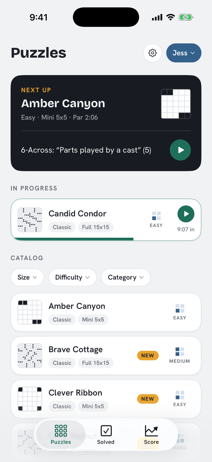 The Puzzles tab: a catalog of crosswords with difficulty badges, a Next Up pick, and an in-progress puzzle